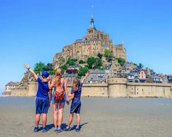 Famille en visite à Mont Saint-Michel, émerveillée par le château perché sur son îlot rocheux.