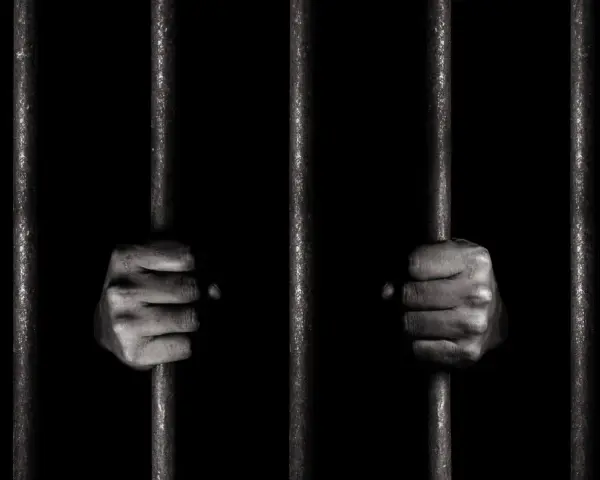 Dwie dłonie zaciskają się na zimnych prętach więziennych. Czy to jego pierwszy raz, czy już recydywista penitencjarny?