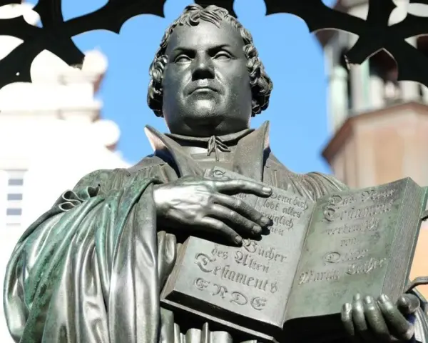 Martin Luther hält eine Bibel. Er erinnert uns daran, wer am Reformationstag frei hat.