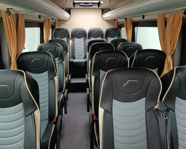 Wnętrze busa z wygodnymi, dwukolorowymi siedzeniami. Idealne do spedycji na busa, zapewniają komfort podróży.