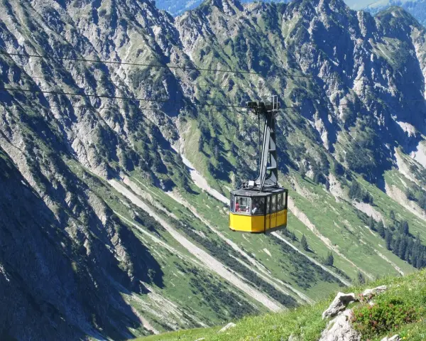 Gelbe Seilbahn schwebt über steile Hänge, ideal für eine Nebelhorn Wanderung.