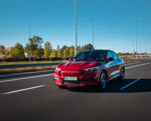 Czerwony Ford Mustang Mach-E jedzie po autostradzie w Polsce.