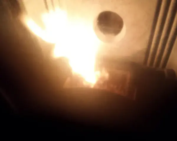Flammes vives dans un poêle Piazzetta, peut-être un problème de tirage. La chaleur intense illumine l'intérieur.