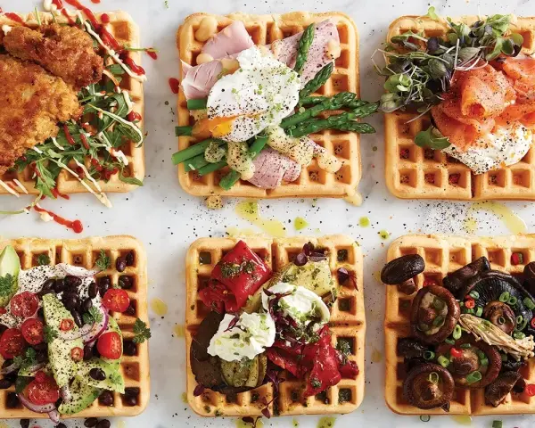 Sex olika protein våfflor: friterad kyckling, pocherat ägg med sparris, rökt lax, avokado och bönor, grillade grönsaker, och svamp.