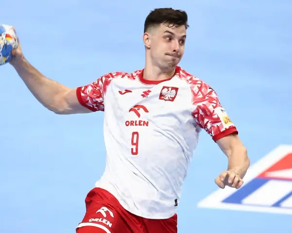 Szymon Sićko w akcji, rzuca piłkę ręczną.