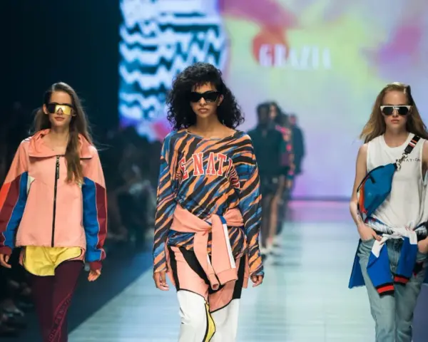 Modelki na wybiegu prezentują stylizacje, które idealnie sprawdzą się, jak się ubrać na imprezę w stylu lat 90. Kolorowe bluzy, dresy i neonowe dodatki.