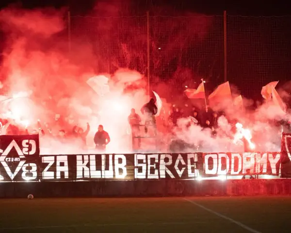 Fani z piłą ręczną, czuwaj przemyśl! Tłum kibiców z racami i flagami tworzy czerwony dym.