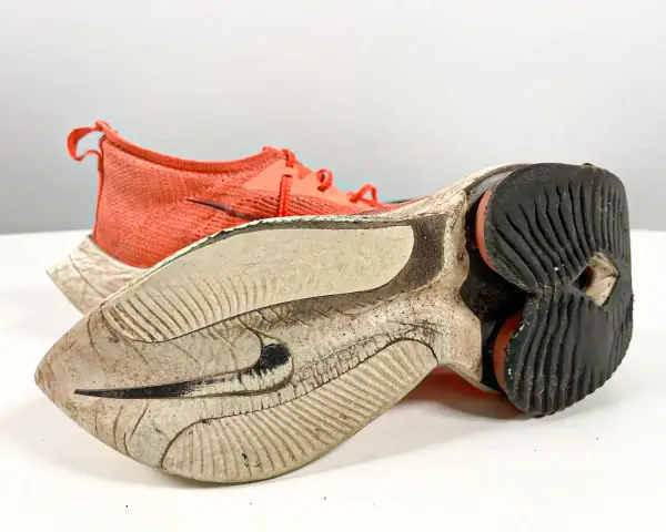 Scarpe da camminata usurate, con suola consumata e tomaia arancione. È ora di cambiarle per continuare a correre in sicurezza.