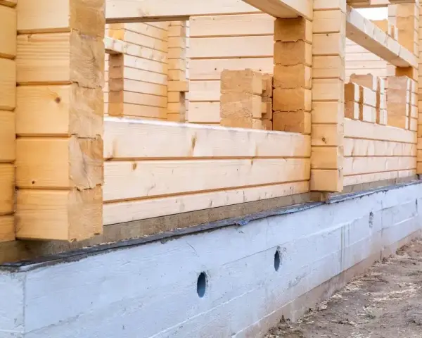 Budowa domu z bali w 2025 roku. Fundament i ściany z drewna w trakcie wznoszenia.