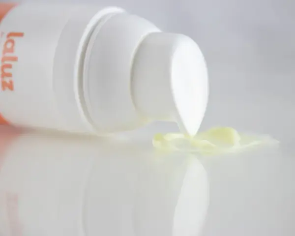 Crema con retinoides que son, de la marca La Luz, con una gota de producto cayendo del dispensador.
