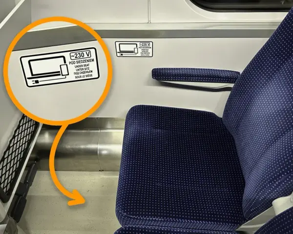 Na siedzeniu w TLK jest naklejka informująca, że pod siedzeniem znajdują się gniazdka 230V.