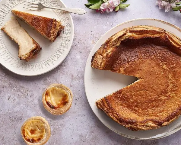 Un pastel de arroz dorado y crujiente, con dos porciones en un plato y dos pastelitos individuales.