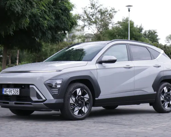 Szary Hyundai Kona Hybrid stoi na zewnątrz, z widocznym przodem i bokiem.