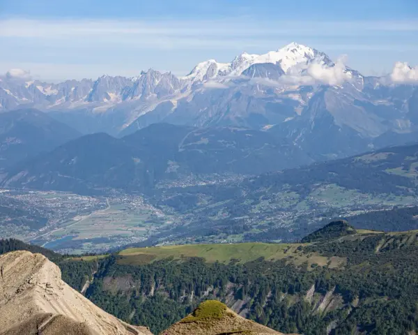 Vue panoramique des Alpes, avec le Mont Blanc enneigé, point culminant des Alpes, dominant la vallée verdoyante et ses villages.