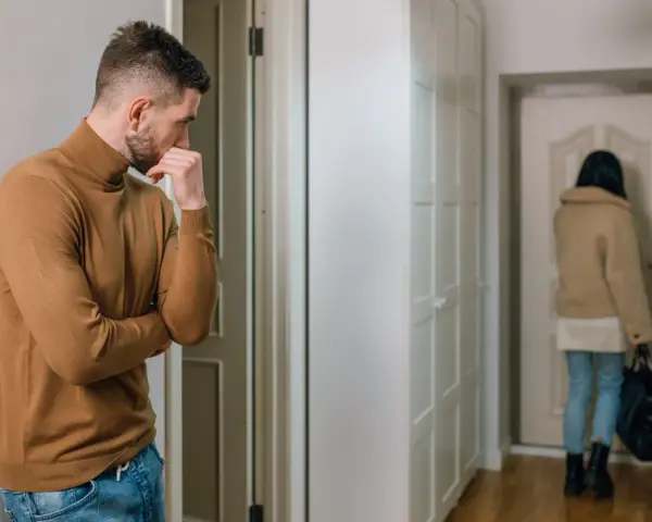 Mężczyzna w golfie zamyślony, gdy kobieta odchodzi. Jak reagować na ghosting?