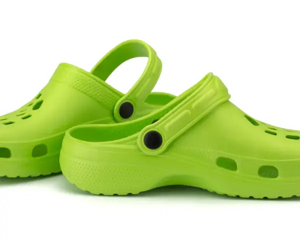 Zapatos verdes tipo crocs, ideales para aliviar la fascitis plantar.