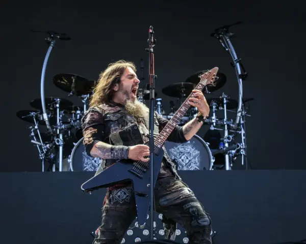 Robb Flynn z Machine Head na jednym z koncertów, w pełni energii, szaleje na czarnej gitarze typu V.