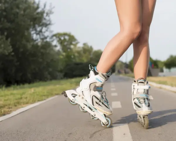 Nogi w rolkach na ścieżce rowerowej. Wspaniałe efekty jazdy na rolkach w letni dzień.