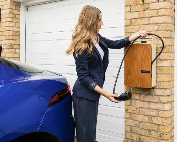 Kobieta podłącza niebieski samochód elektryczny do ładowarki. Szybkie ładowanie dzięki sile 400V.