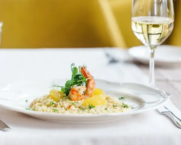 En krämig risotto med räkor och apelsin, perfekt ackompanjerad av ett glas vitt vin till risotto.