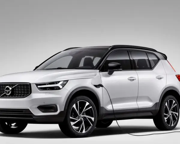 Biały Volvo XC40 Recharge plug-in hybrid podłączony do ładowarki.