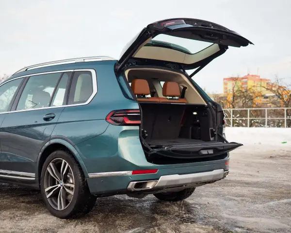 Zielony BMW X7 z otwartym bagażnikiem, idealny na rodzinne wyjazdy. Sprawdź aktualną bmw x7 cena.