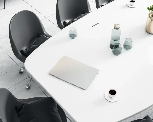 Tavolo da riunione con laptop, bicchieri d'acqua, caffè e un vaso di fiori. Ideale per un ingegnere gestionale lavoro.