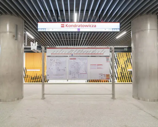 Tablica informacyjna na stacji **metro M2** Kondratowicza. Widoczne schematy stacji, sieci metra i informacje.