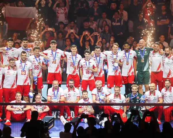 Polscy siatkarze świętują sukces na mistrzostwach świata w siatkówce 2026, z medalami na szyjach i flagą narodową w tle.