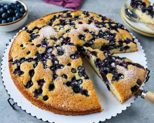 Saftiger Blaubeerkuchen, gebacken nach Omas Rezept. Mit Puderzucker bestäubt und voller Blaubeeren.
