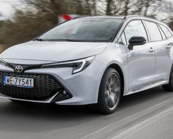 Srebrna Toyota Corolla 2.0 Hybrid w wersji kombi pędzi po drodze.