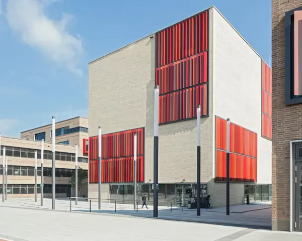 Moderne Gebäude der Hochschule Essen mit hellen Ziegelwänden und auffälligen roten Fassadenelementen.