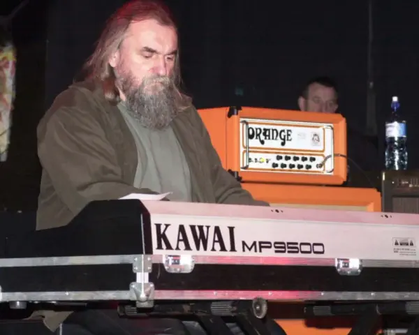 Klawiszowiec zespołu Dżem, z charakterystyczną brodą, gra na keyboardzie Kawai MP9500.