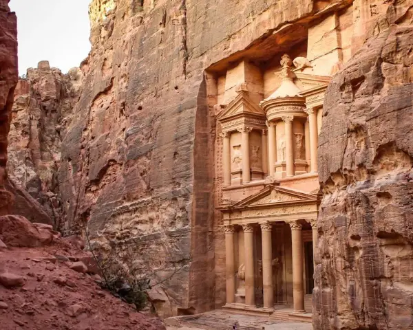 The Treasury in Petra, Jordan, emerges from a narrow canyon. It's a long journey, but how far is Petra from Amman? This ancient city is worth the trip.