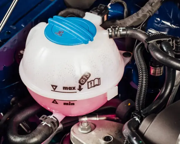 Kühlmittelbehälter eines VW Passat B8. Blasenbildung deutet auf mögliche Probleme mit der Wasserpumpe hin.