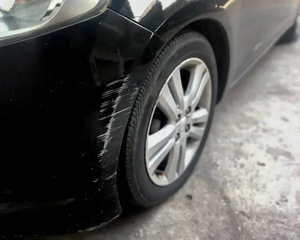 Scratches mar the black paint on a car's fender. Learn how to get scratches out of black car paint to restore its shine.