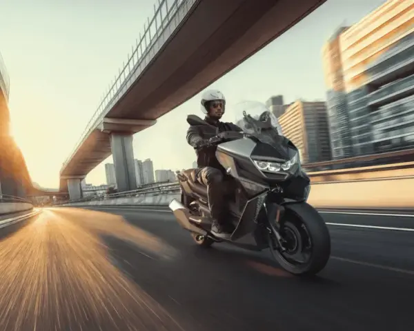Hombre en moto moderna, ideal para **motos para principiantes**, circulando por una autopista urbana al atardecer.