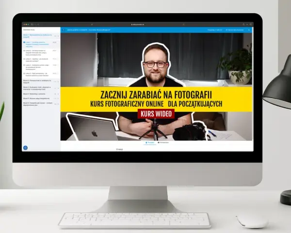 Na ekranie komputera widać kurs fotograficzny online dla początkujących. Mężczyzna w okularach uśmiecha się, zachęcając do nauki zarabiania na fotografii.