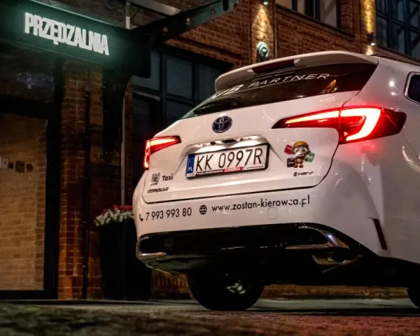 Białe auto z naklejką Bolt i Uber, gotowe do pracy. Kierowca liczy na dobre zarobki.