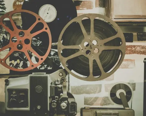 Stare klisze filmowe i projektor, gotowe do odtworzenia historii pełnej emocji i dramatów.