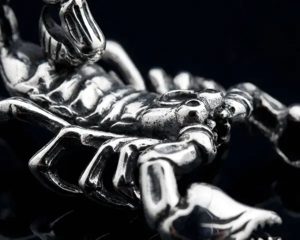 Metalowy symbol skorpiona, z detalami odwzorowującymi jego pancerz i szczypce.