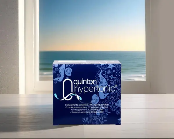 Boîte de Quinton Hypertonic, complément alimentaire, avec une composition marine. La vue sur la mer par la fenêtre évoque la pureté de l'eau de Quinton.