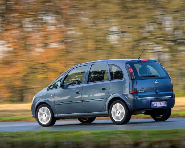 Blauer Opel Meriva A fährt durch eine herbstliche Landschaft. Bekannte Opel Meriva A Schwachstellen sind hier nicht sichtbar.