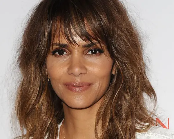 Halle Berry luce un corte shaggy pelo liso con capas que enmarcan su rostro, resaltando su mirada intensa.