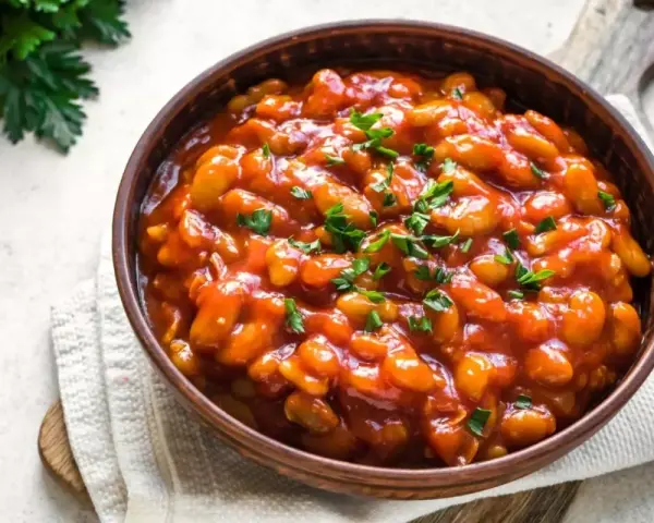 Fagioli in salsa rossa, guarniti con prezzemolo fresco. Un piatto saporito che si possono cuocere all'uccelletto.