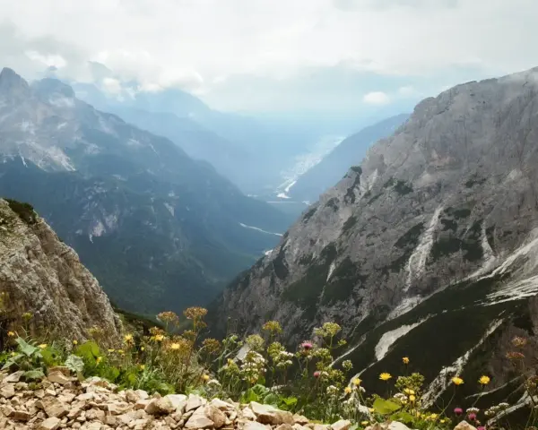 Widok z górskiej ścieżki na dolinę. Czy dolomity to Alpy? Tak, te skaliste szczyty i zielone doliny wyglądają jak Alpy.