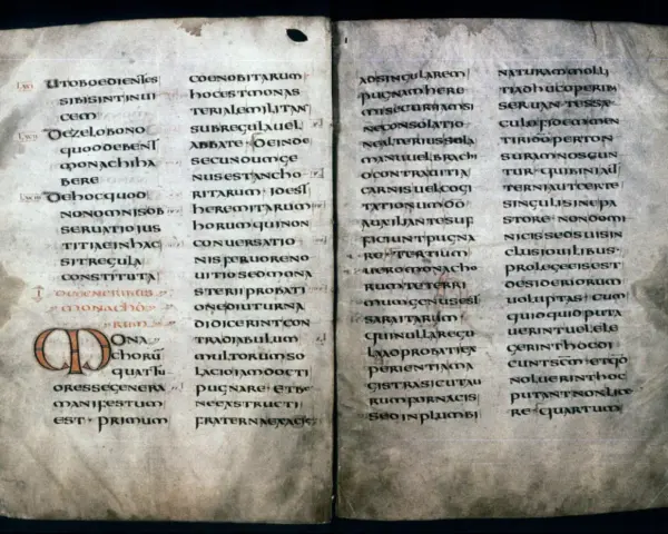 Ancient manuscript page with Latin text, likely a summary of St. Benedict's Rules, featuring ornate initial letters.