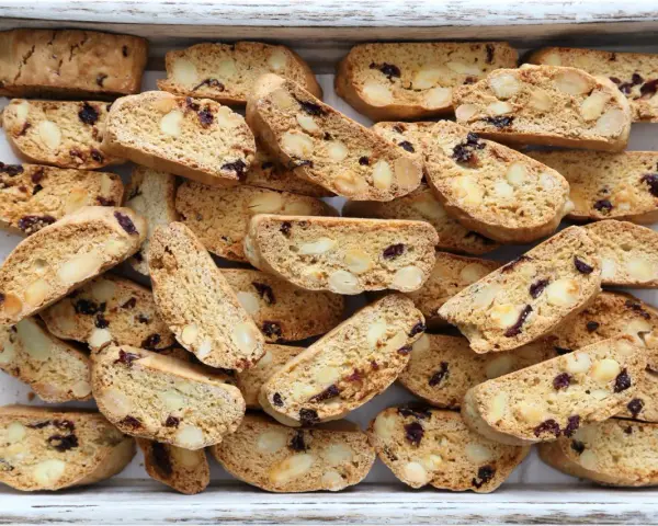 Un vassoio pieno di croccanti biscotti toscani, ricchi di mandorle e mirtilli rossi, pronti per essere inzuppati.