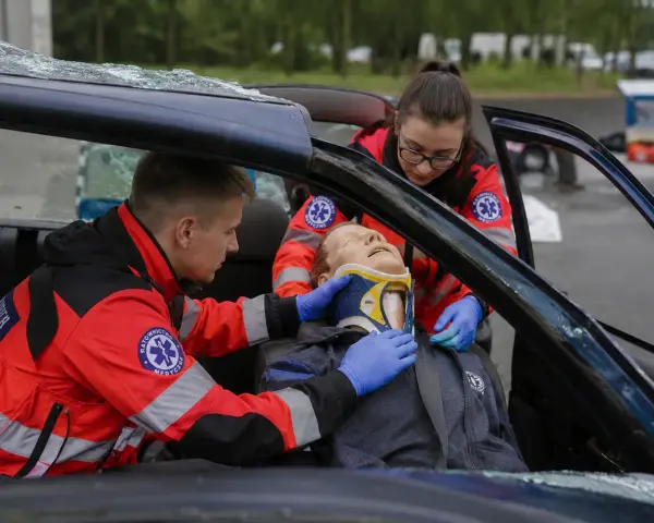 Ratownicy medyczni ćwiczą pomoc poszkodowanemu w wypadku samochodowym. To ważny krok, jak zostać ratownikiem medycznym.
