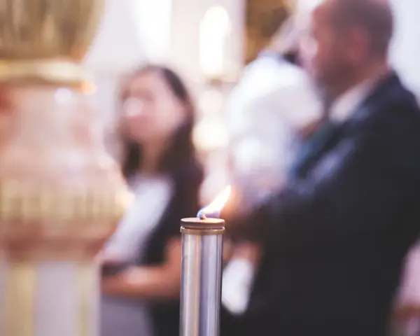 Płonąca świeca podczas uroczystości. Zastanawiasz się, kogo zaprosić na chrzciny?